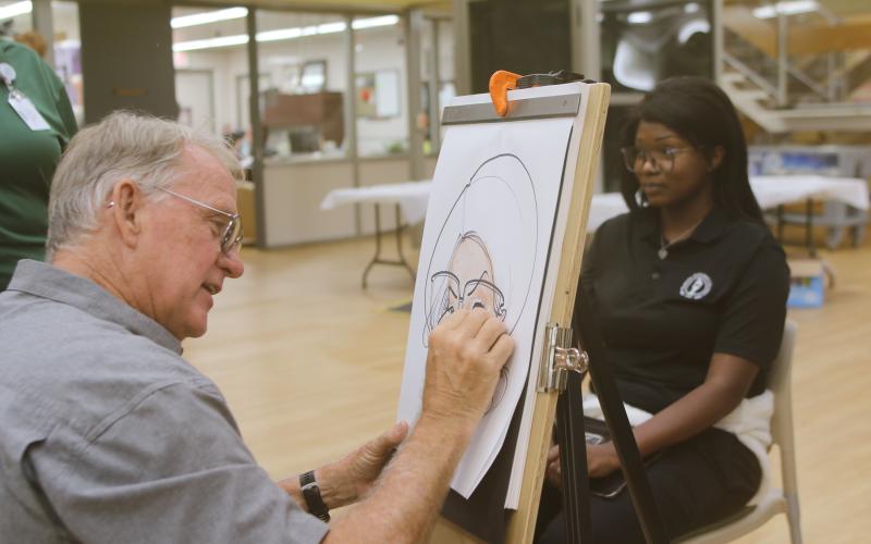 Dino Casterline draws a caricature of Chans Barner on Monday afternoon during Florida Gateway College’s first day of classes for the fall semester. (TONY BRITT/Lake City Reporter)