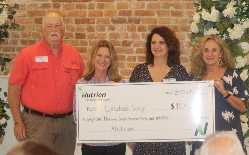Don Fenneman (from left), stands with Jennifer Anchors, Bebe Willis and Pam Hyde as he presents a  check for $91,740 to the United Way of Suwannee Valley during the agency’s breakfast meeting on Thursday. (TONY BRITT/Lake City Reporter)