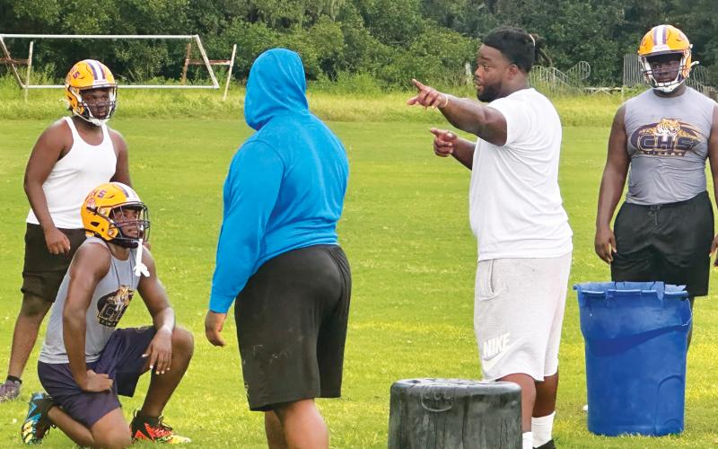 Former Columbia star Timmy Jernigan (right), who went on to play collegiately at Florida State and in the NFL, coaches up Columbia’s defensive line during Monday’s practice. (JORDAN KROEGER/Lake City Reporter)