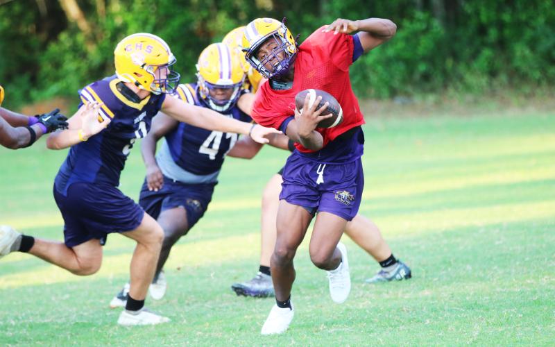 Columbia quarterback Xavier Collins avoids a sack by defensive end Kyten Davis during Thursday's practice. (JORDAN KROEGER/Lake City Reporter)
