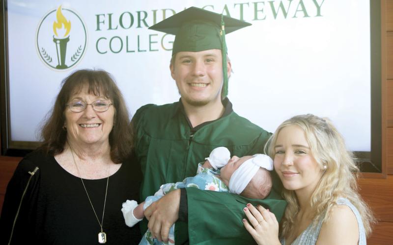 Ryan Appling holds his baby, Aubree, after graduating from Florida Gateway College on Thursday. Also pictured with Appling are Sherri Whitaker (left) and Lacee Ellis (right). (TONY BRITT/Lake City Reporter)