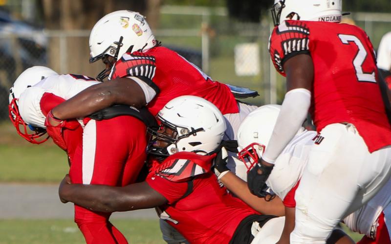 Fort White defensive linemen Chris Smith (top) and Jaden McCray (bottom) combine for a tackle against NFEI during the Preseason Classic on Aug. 15. (BRENT KUYKENDALL/Lake City Reporter)