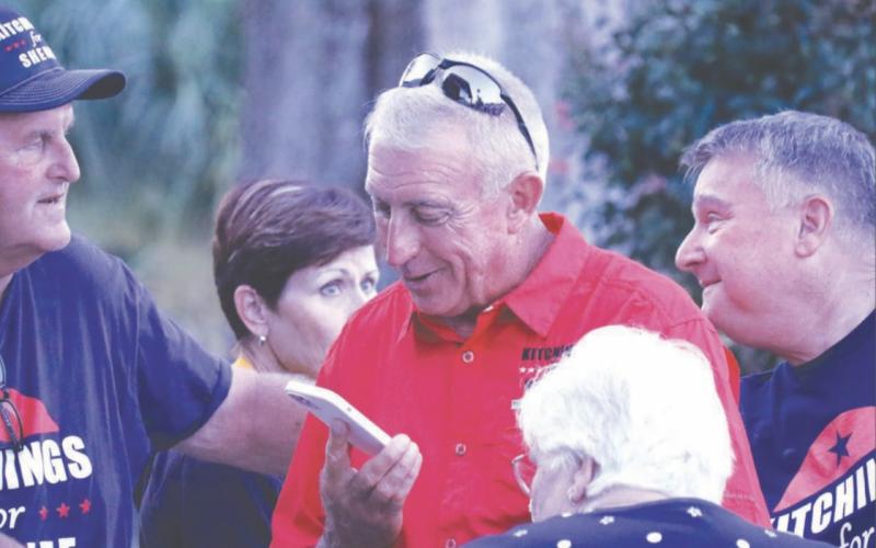 Wallace Kitchings (center) speaks on the phone after learning he’d won the race to be the next Columbia County Sheriff on Tuesday. Now, Kitchings says he’s invested in building relationships with the community. (JAMIE WACHTER/Lake City Reporter)