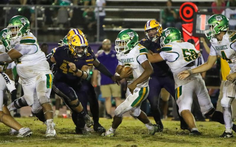 Suwannee running back Lou Jack Smith looks for running room as Columbia defensive lineman Caden Bolstein rushes in for a tackle last Friday. (BRENT KUYKENDALL/Lake City Reporter)