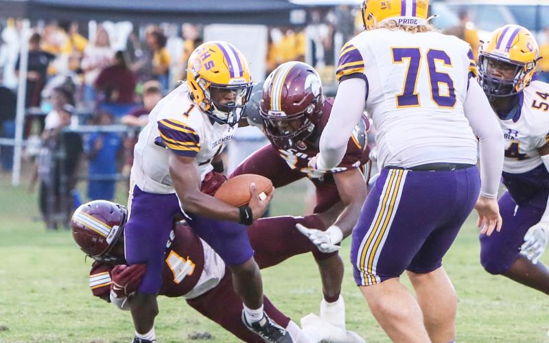 Columbia quarterback Zamarion Jones is bottled up by a pair of Coffee defenders on Friday night. (BRENT KUYKENDALL/Lake City Reporter)