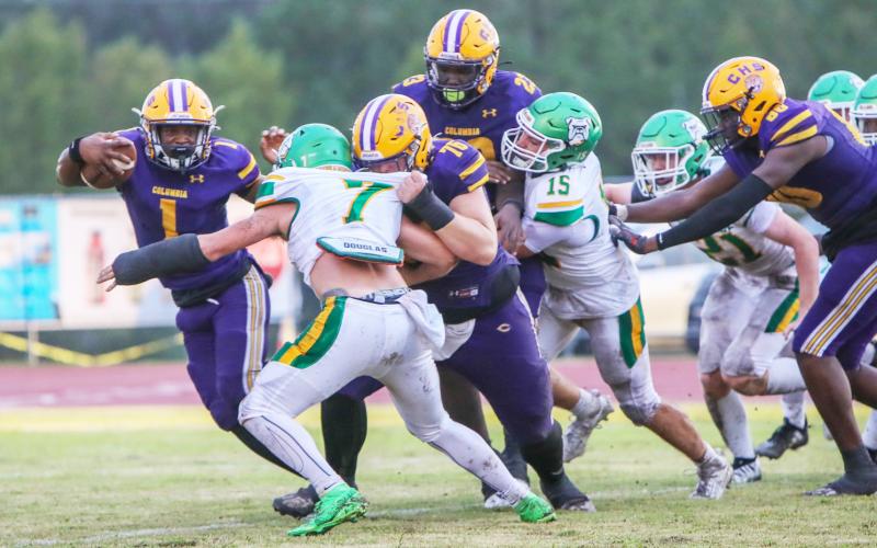 Columbia quarterback Zamarion Jones scrambles up field as center Zackery Grimes blocks Suwannee linebacker Jace Moran during Friday’s game. (BRENT KUYKENDALL/Lake City Reporter)