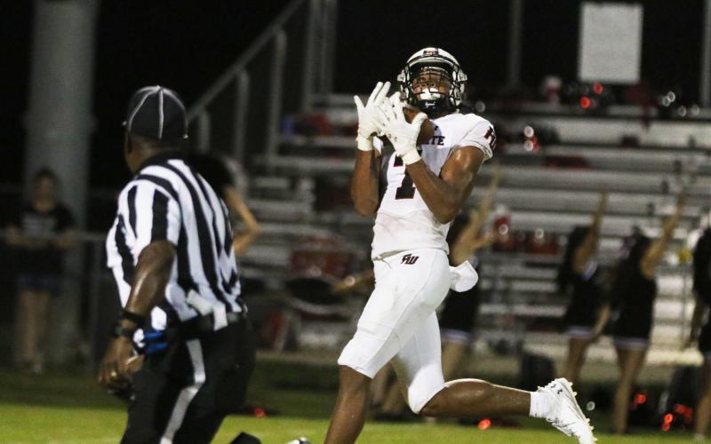 Fort White receiver Tafari Moe catches a long scoring pass against Belleview on Friday night. (MORGAN MCMULLEN/Lake City Reporter)
