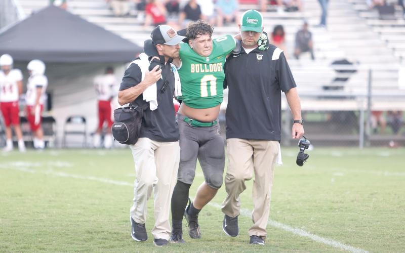 Suwannee linebacker Christian Socarras is helped off the field by the team trainer (left) and head coach Kyler Hall after injuring his knee during Friday’s Preseason Classic against Bishop Kenny. (PAUL BUCHANAN/Special to the Reporter)