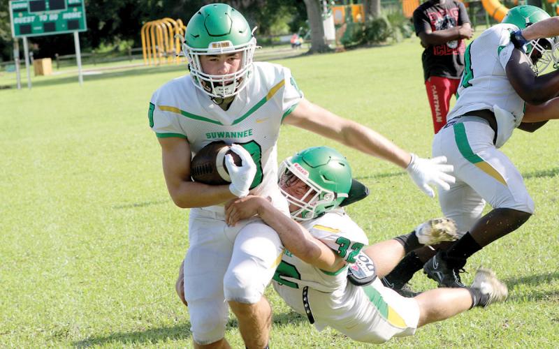 Suwannee receiver Koy Frier runs up the field for yardage as linebacker Christian Soccares dives for a tackle during an intrasquad scrimmage on Aug. 3. (JAMIE WACHTER/Lake City Reporter)