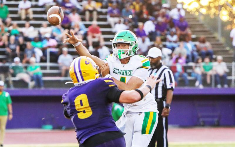 Suwannee quarterback Thomas Sikes throws a pass as Columbia defensive end Kyten Davis applies pressure on Friday. (BRENT KUYKENDALL/Lake City Reporter)