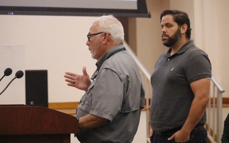Columbia County Code Enforcement Officer Winston Warner talks to the County Commission about issues with complaints in the Town of Fort White on Thursday while Alexander Veiga, co-owner of The Collective: Food Yard and Garden, looks on. The commission voted to terminate its agreement to handle code enforcement for the town. (JAMIE WACHTER/Lake City Reporter)