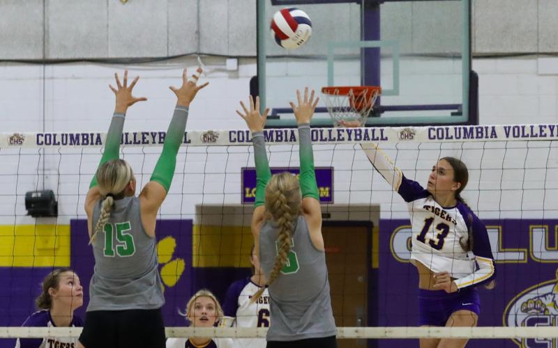 Columbia hitter Kayla Goodloe fires a shot as Suwannee's Maci Hingson (15) and Brooke Fernald (5) defend on Sept. 3. (BRENT KUYKENDALL/Lake City Reporter)