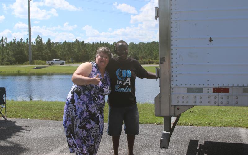 Lisa Gould-Kinney hugs truck driver Sam Lagat after picking up some ice at the Southside Sports Complex on Sunday afternoon to provide some relief in the hot weather after Hurricane Helene. (TONY BRITT/Lake City Reporter)