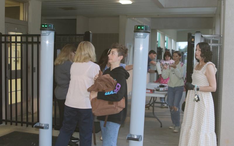 A Fort White student anxiously looks at the detection lights on one of the school’s new metal detectors while passing through. Fort White High added four metal detectors Monday morning to increase school security after threats last week. (TONY BRITT/Lake City Reporter)