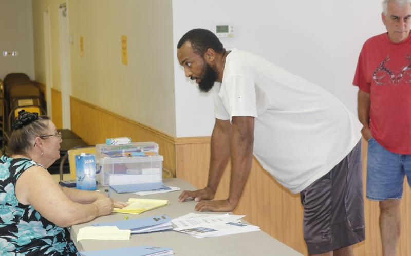 Tylin Jones signs in at the Fort White Community Center to pick up water and MREs. The Fort White location is one of a handful throughout the county where residents impacted by Hurricane Helene can pick up needed supplies. (JAMIE WACHTER/Lake City Reporter)