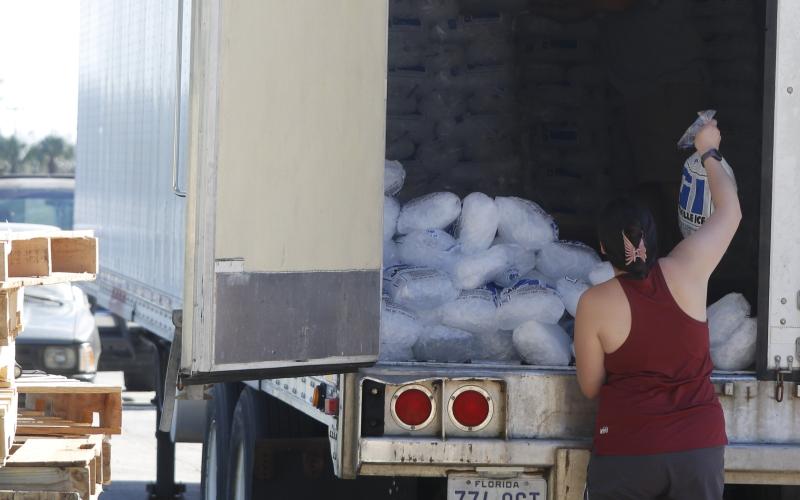 A visitor to the Fort White Community Center on Sunday grabs a bag of ice off the back of a semi truck that was supplying ice to those without power after Hurricane Helene. (STASI WACHTER/Lake City Reporter)