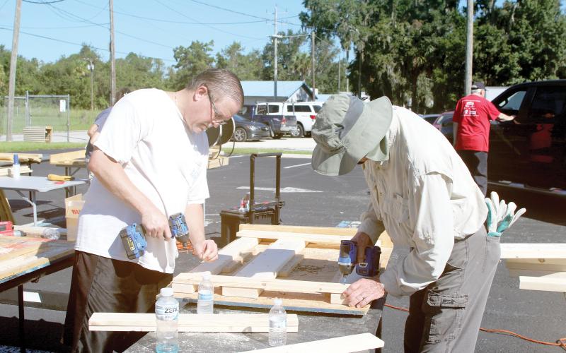 Chris Costello (from left) and Steve Stafford work on making a headboard during the Sleep in Heavenly Peace Bunks Across America event Saturday at the Christian Service Center. Volunteers planned to make 20 beds during the event. (TONY BRITT/Lake City Reporter)