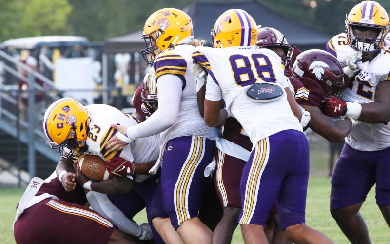 Columbia running back Johnathan Andrews fights for yardage as center Zackery Grimes (middle), tight end Aaron Holmes (88) and right guard Chase Johnson (72) try to block Coffee defenders on Friday. (BRENT KUYKENDALL/Lake City Reporter)