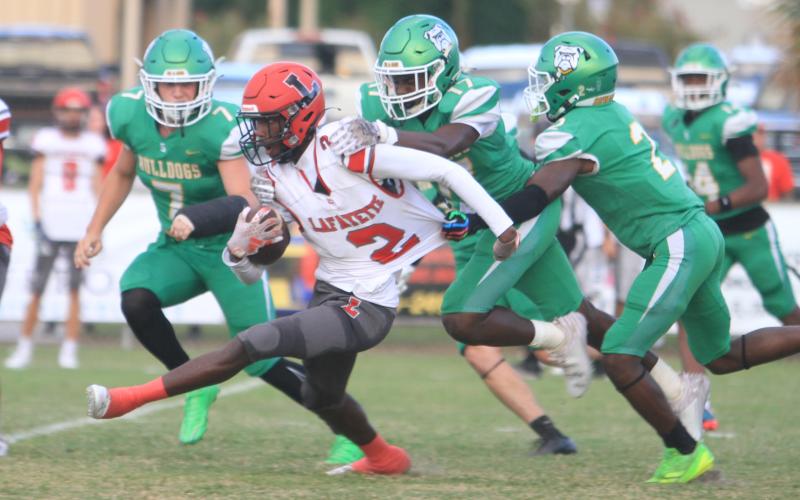 Lafayette receiver Jordan Murphy tries to pull away from Suwannee defenders JaDarius Horne (2), Travis Fead (17) and Jace Moran (7) last Friday. (PAUL BUCHANAN/Lake City Reporter)