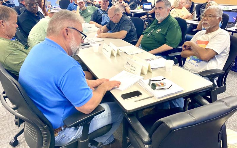 Assistant County Manager Kevin Kirby (left, blue shirt) gives a road debris cleanup report to county commissioners Saturday during the daily briefing at the Columbia County EOC bunker. (TODD WILSON/Lake City Reporter)