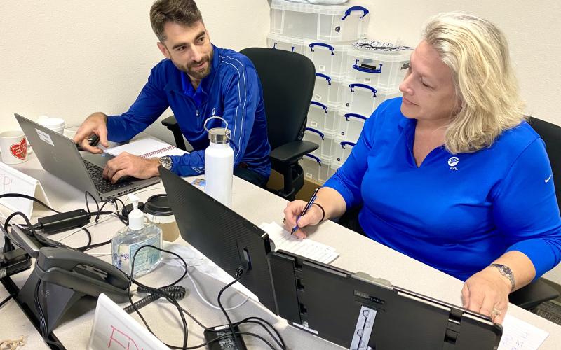 Florida Power and Light Emergency Operations Center Representative Colin Hughes (left) and Carol Saviak, FPL External Affairs Manager - North Florida, discuss recovery and restoration operations in Columbia County Saturday afternoon in Lake City. FPL says 95% of its customers in Columbia County will have power sometime Monday. (TODD WILSON/Lake City Reporter)