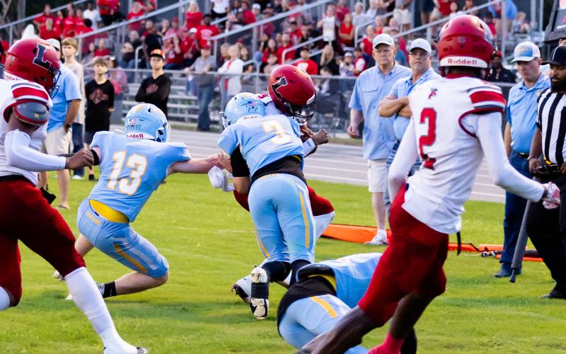 Lafayette quarterback Tywan Williamson is hit hard by Chiefland safety Jolan Doty on Friday. (JACK HOWDSHELL/Lake City Reporter)