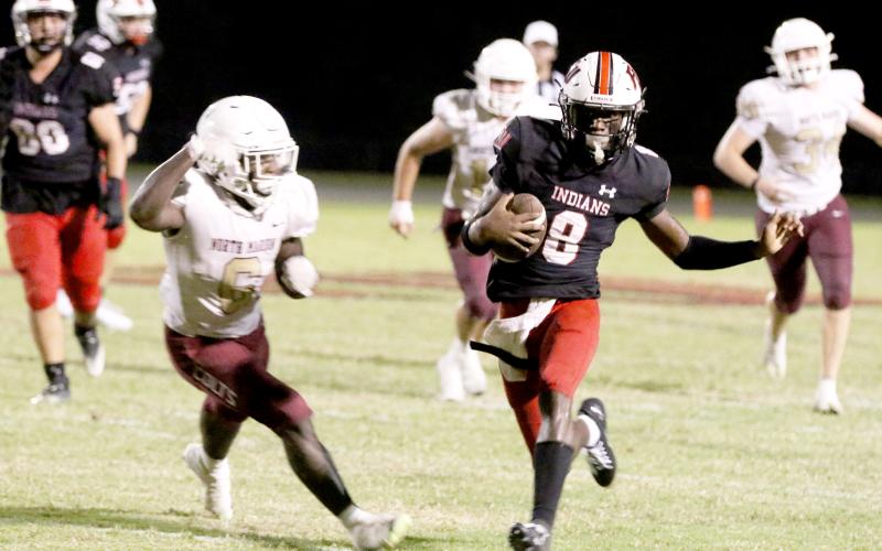 Fort White quarterback Jayden Jackson scrambles against North Marion last Friday night. (MORGAN MCMULLEN/Lake City Reporter)
