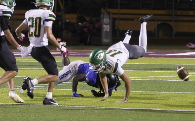 Godby’s Qyntrel Strong upends AJ Hitt after a bad punt snap in the fourth quarter of Friday’s game. (JAMIE WACHTER/Lake City Reporter)
