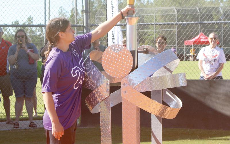 Columbia County athlete Rachel Saye places the torch into a stand during the opening ceremonies Saturday at the Southside Sports Complex. (TONY BRITT/Lake City Reporter)