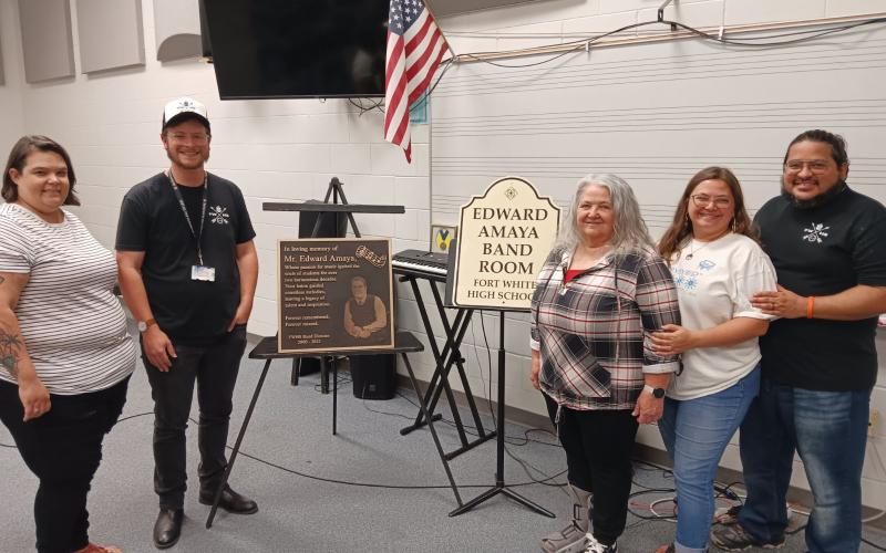 Heather Carraway (from left) stands with David Harris, Fort White High School band director, as they show a plaque and bandroom dedication placard for the late Ed Amaya. Amaya’s family members Peggy Amaya, Miranda Amaya-Firpo and Rafael Amaya-Firpo were also attended the program. (TONY BRITT/Lake City Reporter)