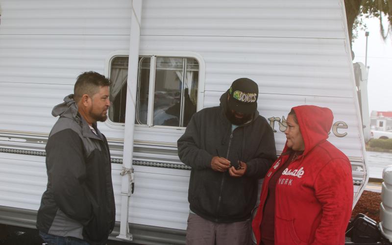 Amanda Ramirez (right) and her family members hold a conversation while their camper is parked in the Walmart parking lot. Ramirez and family evacuated from Manatee County a few days ago to avoid Hurricane Milton. (TONY BRITT/Lake City Reporter)