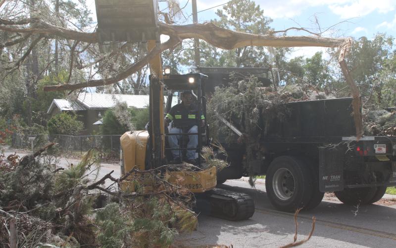 A Lake City Public Works employee helps clear debris from the roadside left in the wake of Hurricane Helene. Lake City Executive Director of Utilities Steve Brown, who also oversees public works, said additional crews have been brought in to help with the effort. (TONY BRITT/Lake City Reporter)