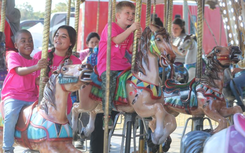 De’Mari Jackson (from left), Mya Villar and Parker Spin, are all smiles while riding the carousel Tuesday morning at the Florida Gateway Fair. (TONY BRITT/Lake City Reporter)