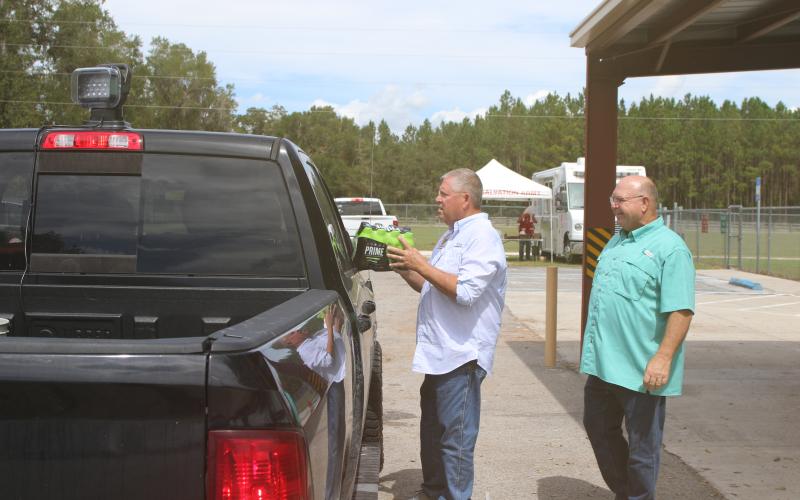 State Rep. Chuck Brannan (left) and Columbia County Commissioner Rocky Ford help pass out drinks and food to people mpacted by Hurricane Helene at the Fort White Community Center on Thursday. (TONY BRITT/Lake City Reporter)