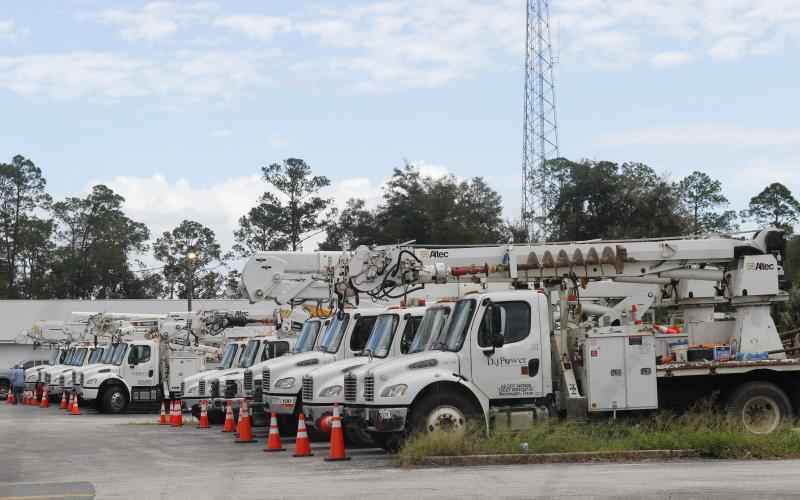 Power trucks line the former I-75 Autos site on Duval Street on Thursday, waiting to head south to help after Hurricane Milton. (JAMIE WACHTER/Lake City Reporter)