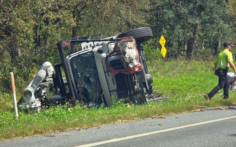 Three linemen from North Carolina were injured when their bucket truck overturned as part of a four-vehicle crash northwest of Jasper on Wednesday afternoon. A Jasper man was killed in the crash. (COURTESY)