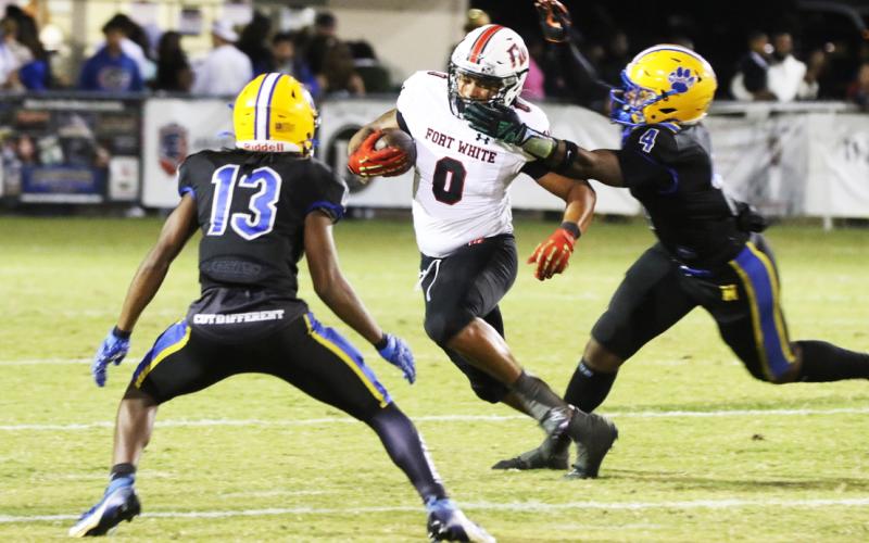 Fort White running back Lecosta Byrd gets his facemask grabbed by Newberry linebacker Logan Mccloud on Friday night. (MORGAN MCMULLEN/Lake City Reporter)