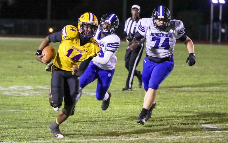 Columbia quarterback Xavier Collins scrambles up field away from the Ridgeview defense on Oct. 11. (BRENT KUYKENDALL/Lake City Reporter)