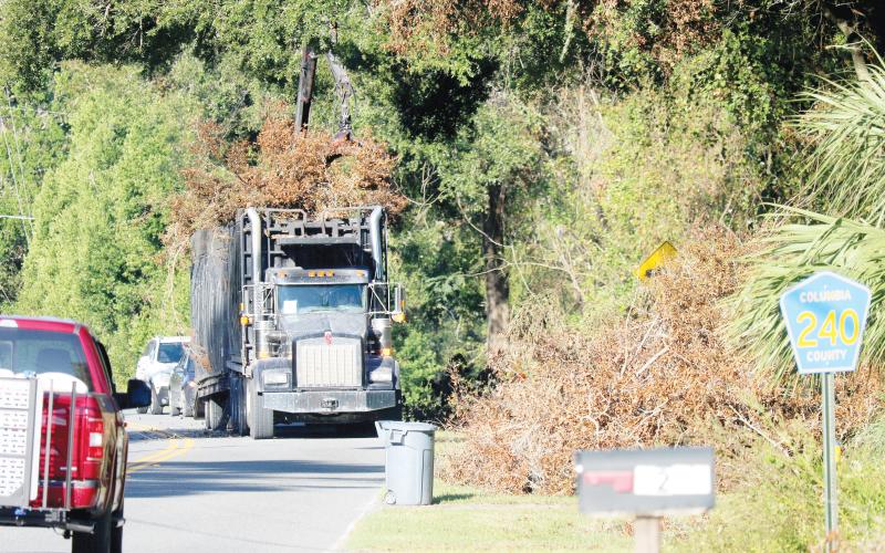 A storm debris removal contractor picks up debris along County Road 240 on Tuesday morning. The county’s efforts to clean up the record amount of debris from Hurricane Helene will be slowed by Hurricane Milton. (JAMIE WACHTER/Lake City Reporter)