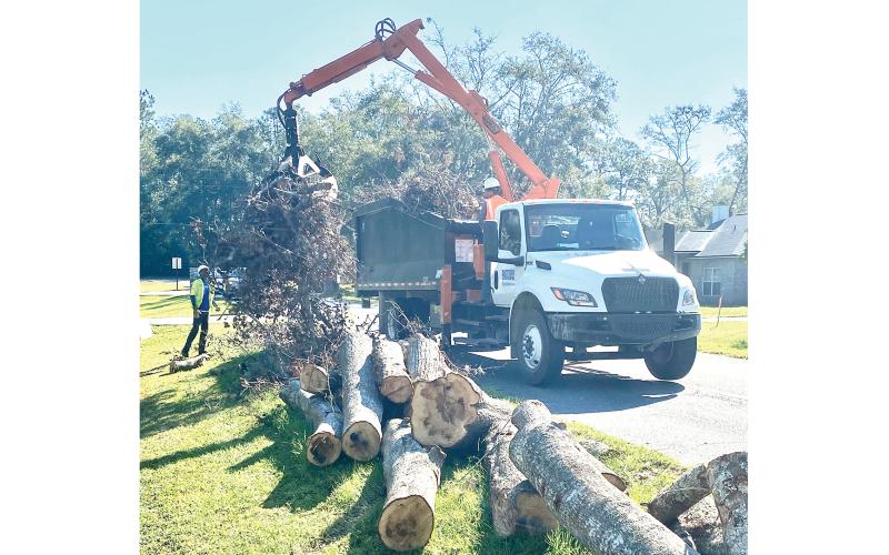 Contractor crews working for Ceres, and contracted with Columbia County to assist with the cleanup of storm debris following Hurricane Helene, pick up stacked debris in the right of way along NW Winding Way on the county’s west side last weekend. (TODD WILSON/Lake City Reporter)