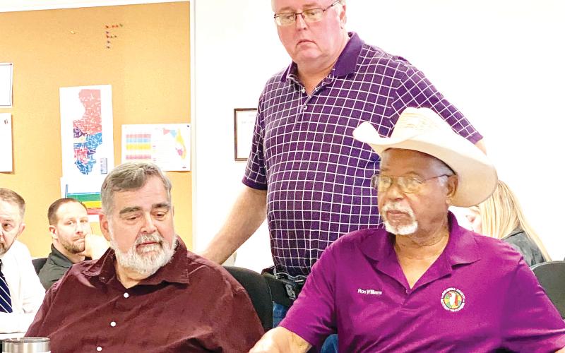 County Manager David Kraus (from left), Emergency Management Director Shayne Morgan and County Commissioner Ron Williams discuss Hurricane Milton prior to an emergency meeting Wednesday morning. (TODD WILSON/Lake City Reporter)