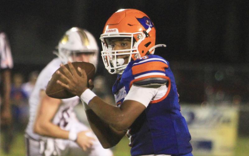 Branford quarterback Damian Herrera rolls out to pass against Oak Hall on Aug. 23. (PAUL BUCHANAN/Lake City Reporter)