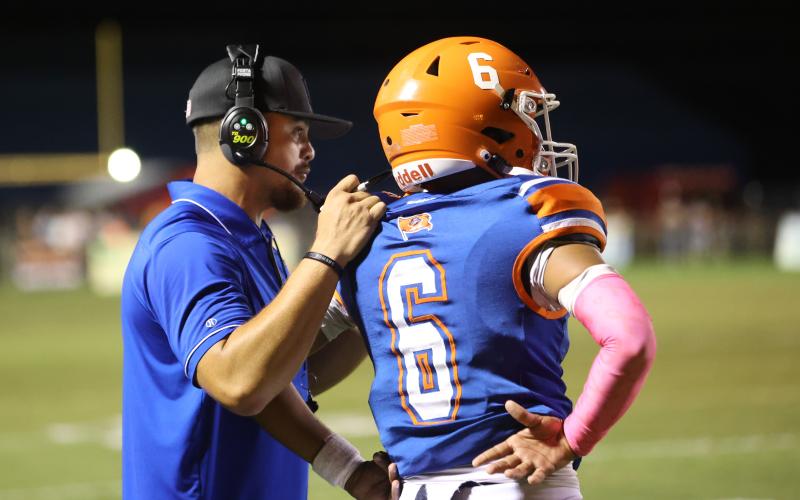 Branford head coach Tim Clark (left) talks to quarterback Damian Herrera during last Friday’s game against Trenton. (PAUL BUCHANAN/Lake City Reporter)