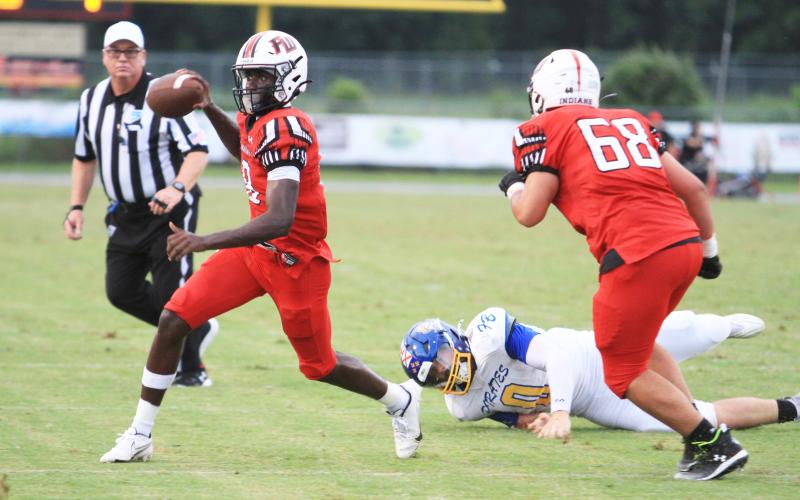 Fort White quarterback Jayden Jackson scrambles away from pressure against Fernandina Beach on Sept. 13. (PAUL BUCHANAN/Lake City Reporter)