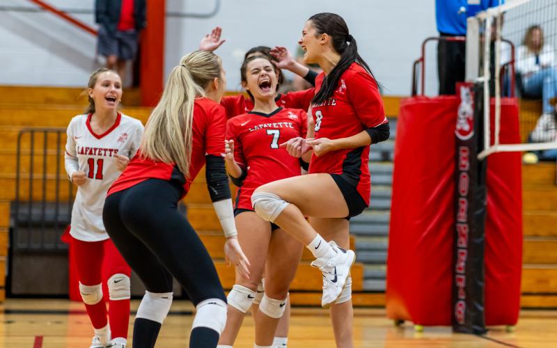 Lafayette volleyball players Ella McAdams (11), Havyn Richardson (middle left), Libby Beach (7) and Kiley Beach (8) celebrate after scoring a point against Columbia on Sept. 24. (JACK HOWDESHELL/Lake City Reporter)