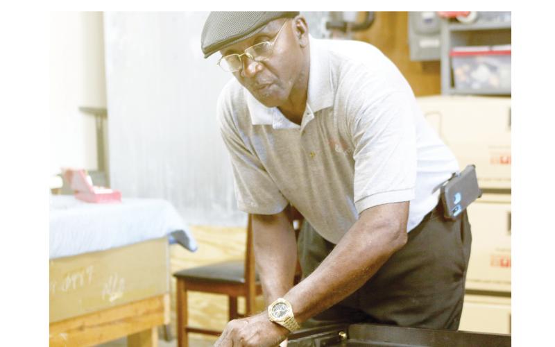 Robert Nelson, assembling a bed’s headboard, said the furniture has gotten heavier during the past five decades. (TONY BRITT/Lake City Reporter)