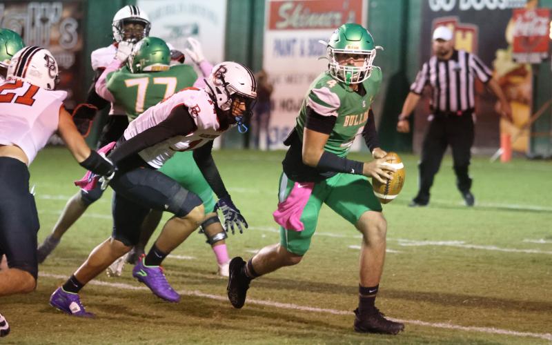 Suwannee quarterback Thomas Sikes rolls away from pressure during Friday's game against Baker County (PAUL BUCHANAN/Lake City Reporter)