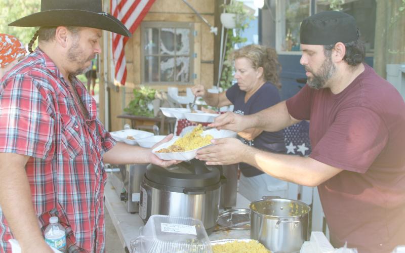 Alexander Veiga, co-owner of The Collective, (right) serves up food during Monday’s event. (TONY BRITT/Lake City Reporter)