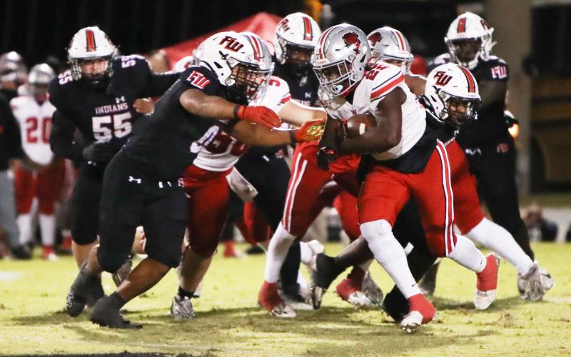 Fort White linebacker Lecosta Byrd (0) goes to wrap up Red Devils running back Jamari Williams Friday at Arrowhead Stadium. (BRENT KUYKENDALL/Lake City Reporter)