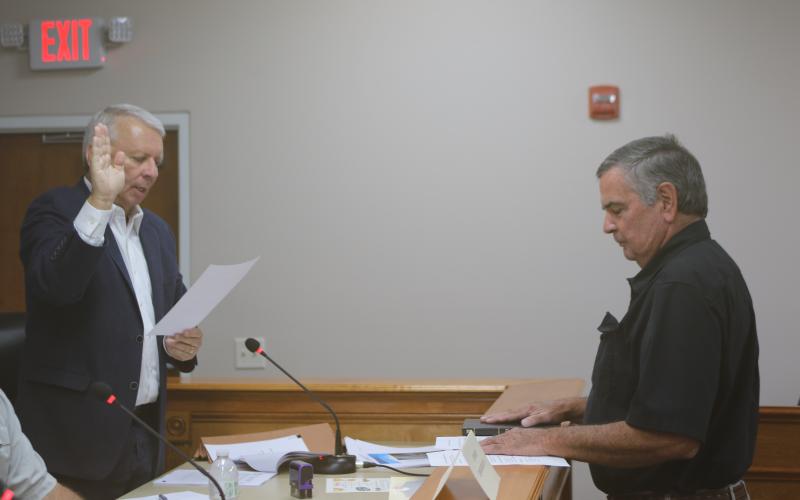 Grady Williams (from left), North Florida Water Utilities Authority Board of Directors legal counsel, swears in Steven Dicks as the board member at-large for the entity. (TONY BRITT/Lake City Reporter)